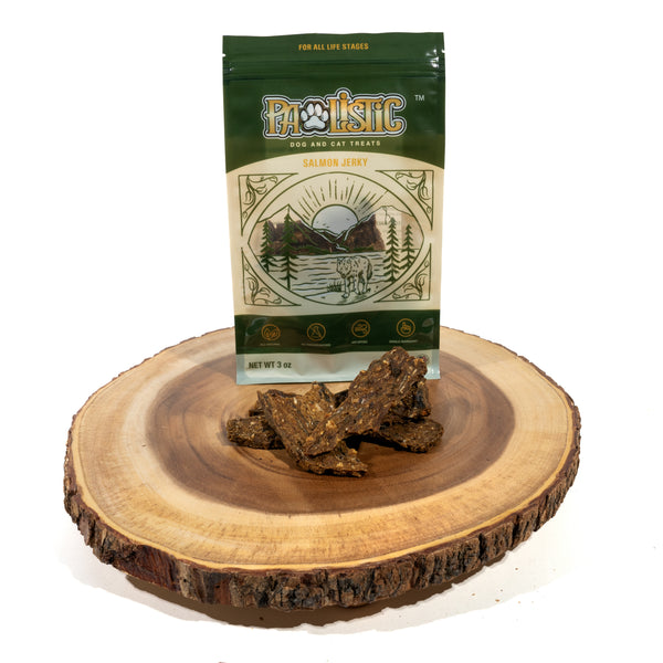 An image of Salmon Jerky Treats for dogs and cats being displayed on a tree stump